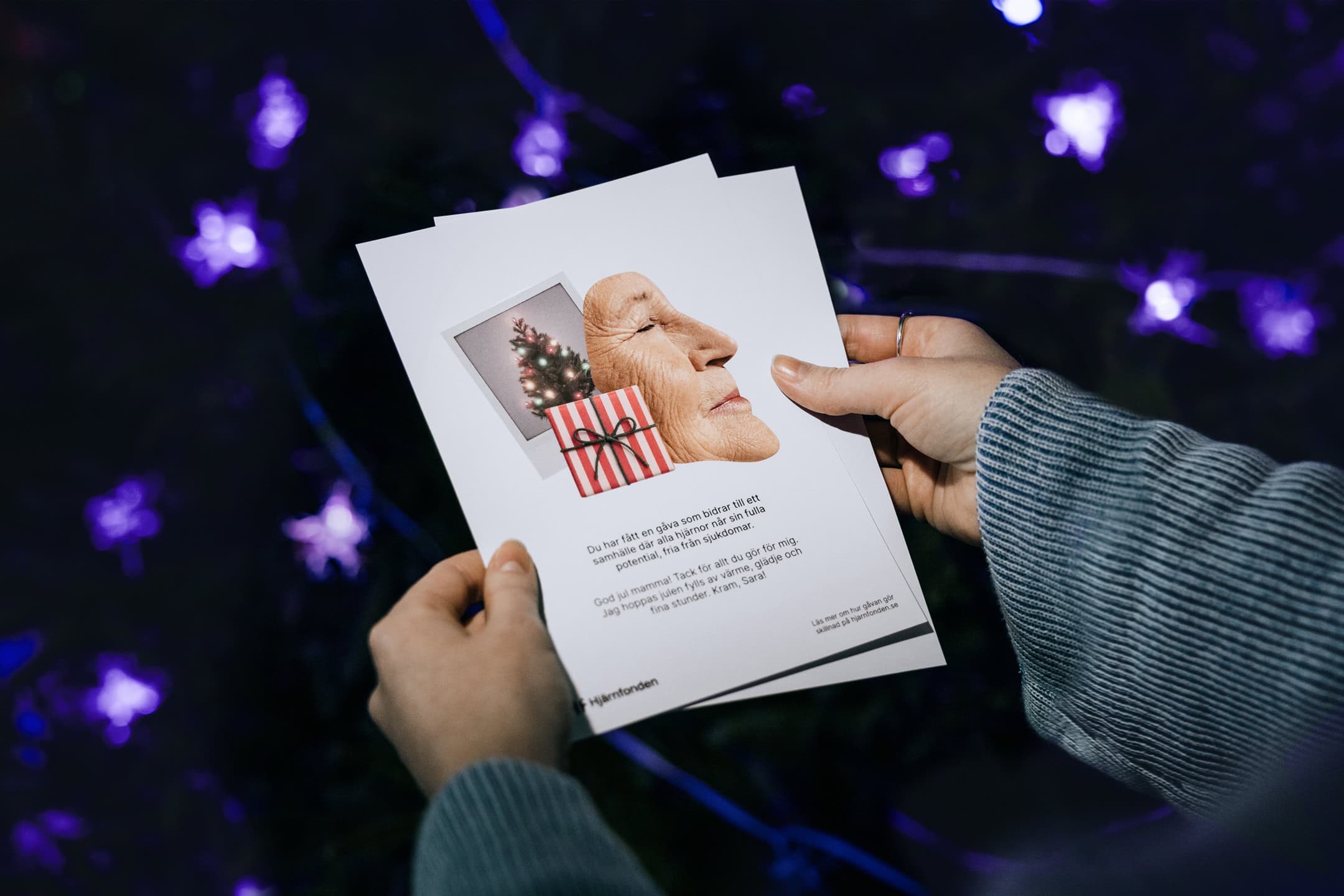 Person håller i gåvobevis med julmotiv och personlig hälsning.