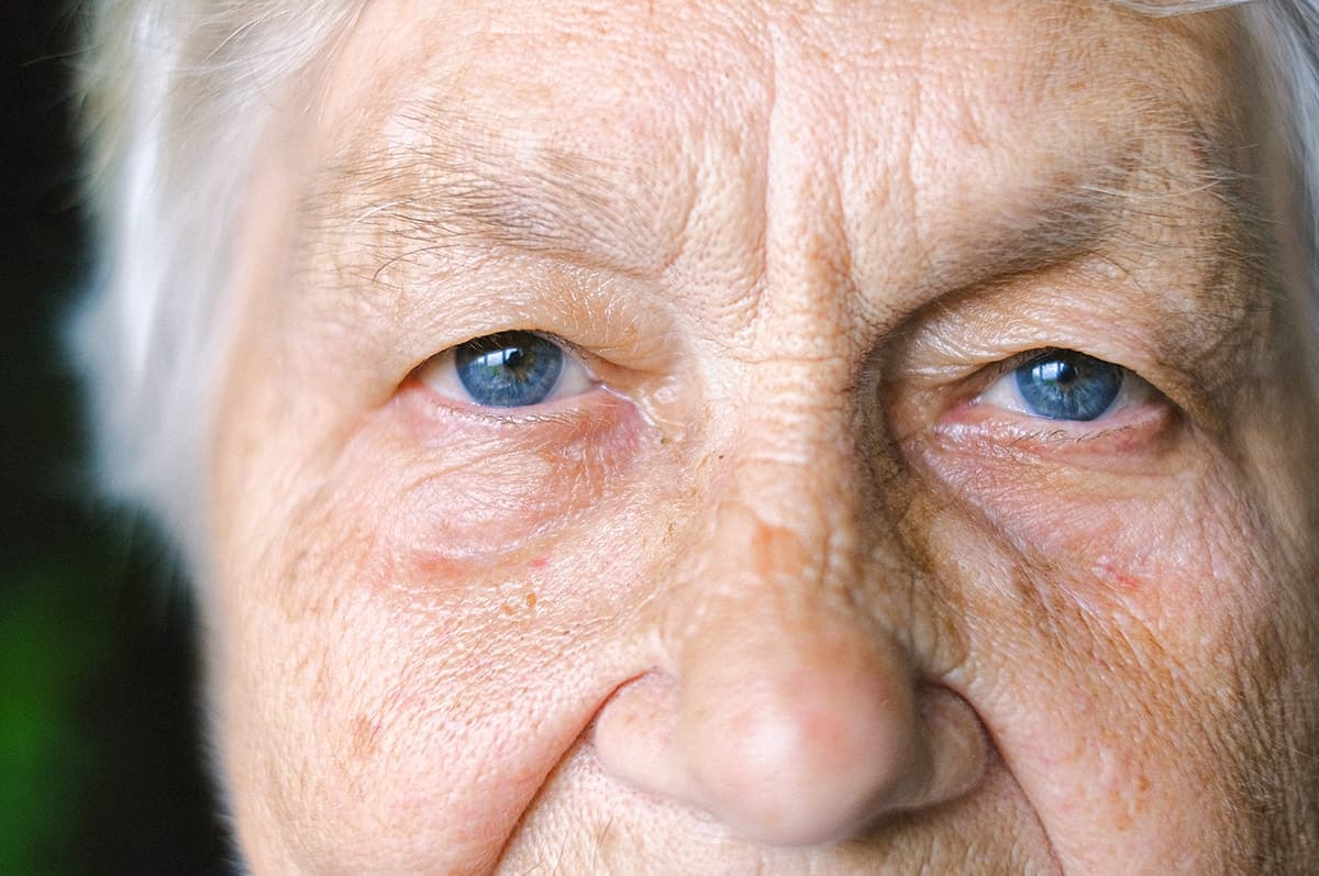 En äldre dam kollar rakt in i kameran.